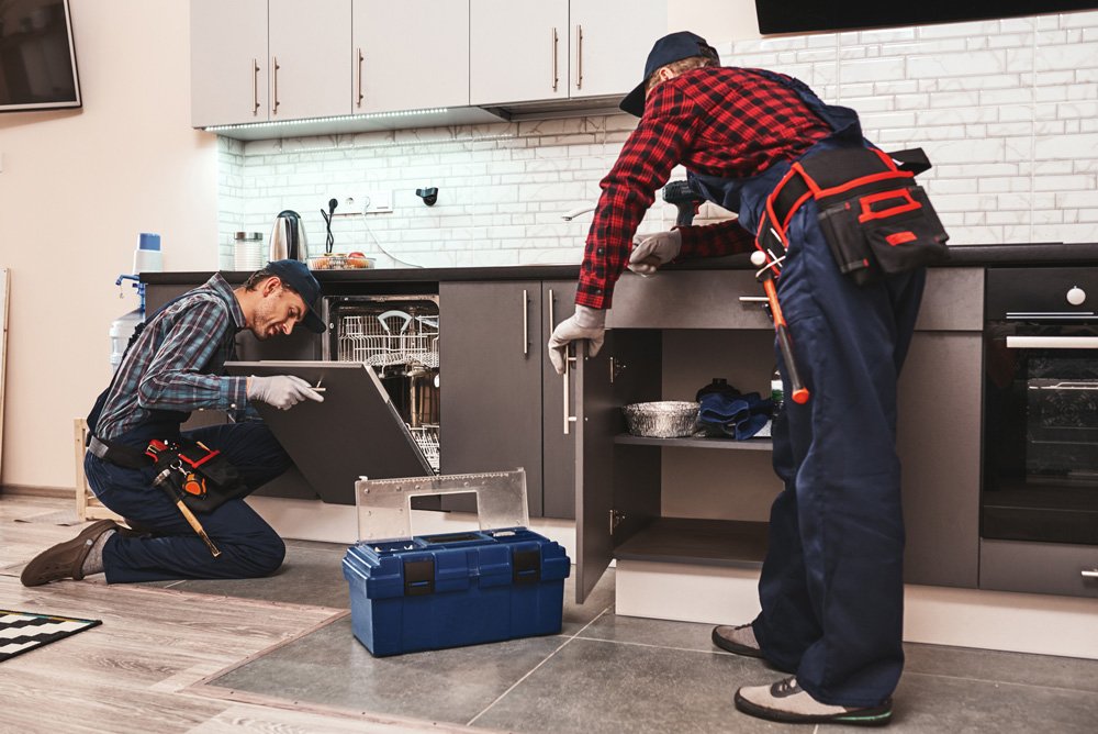 Technicians repairing a dishwasher
